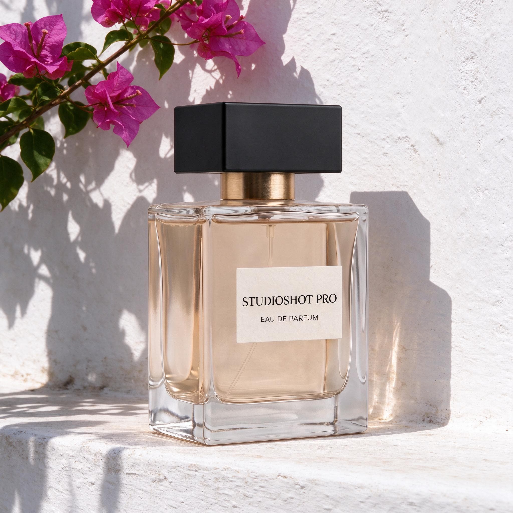 Perfume bottle on a sunlit whitewashed ledge beneath magenta bougainvillea