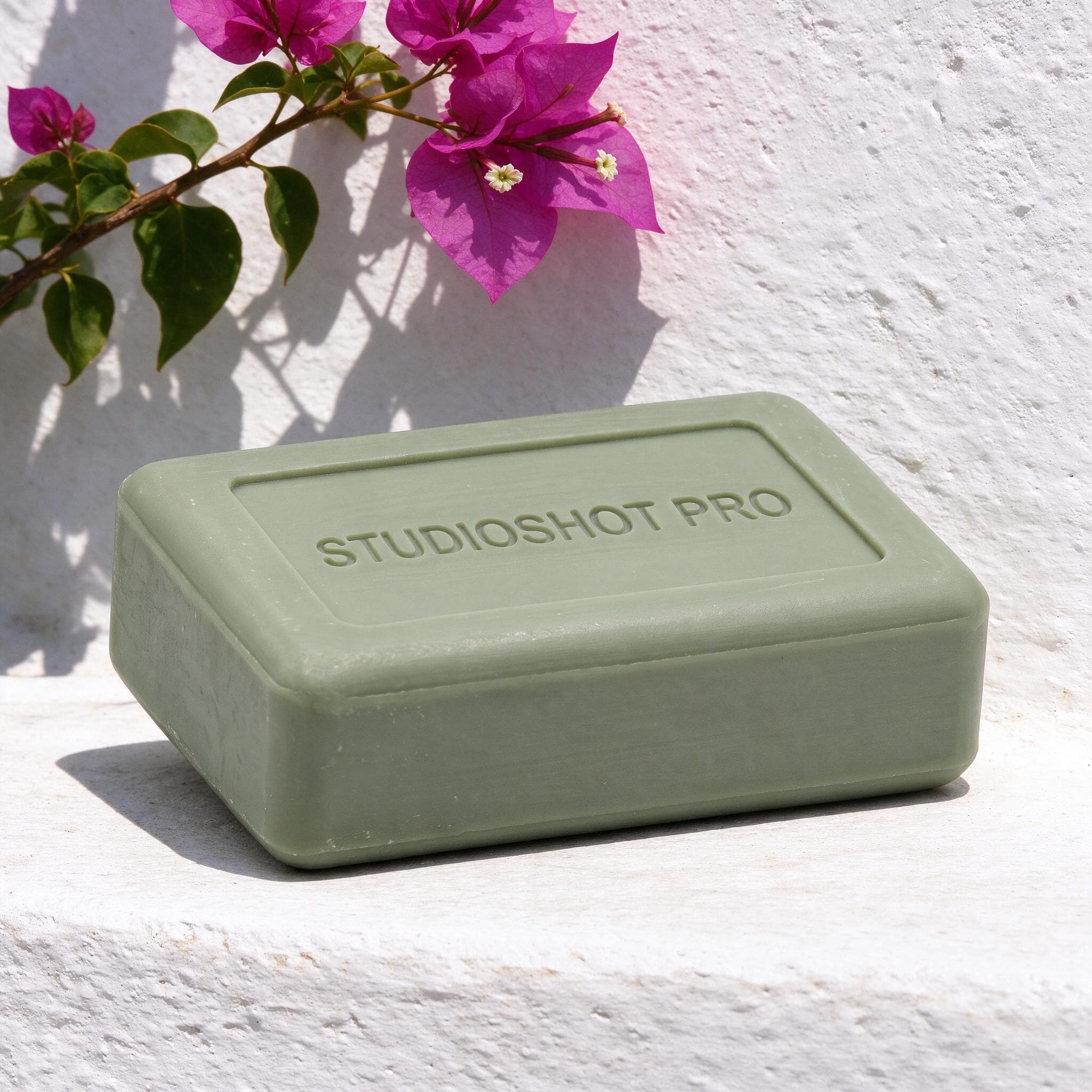 Sage-green soap bar on a sunlit whitewashed ledge beneath magenta bougainvillea